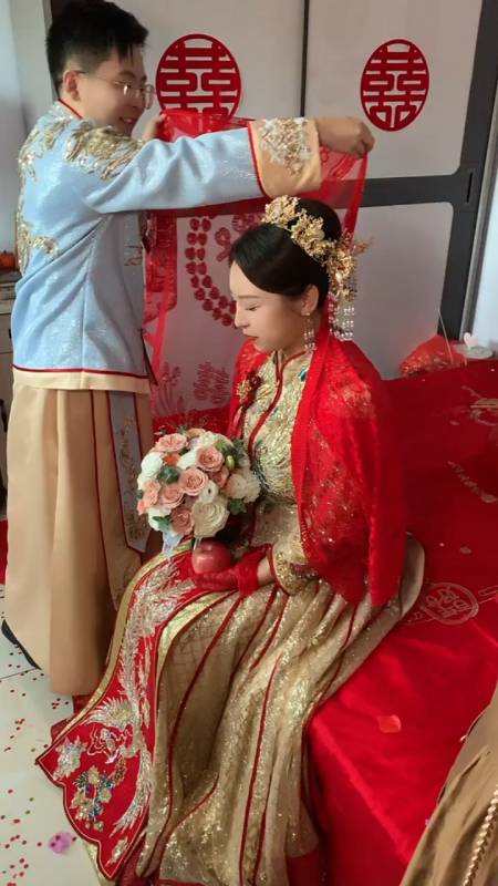 新郎给新娘披上红盖头迎娶新娘回家