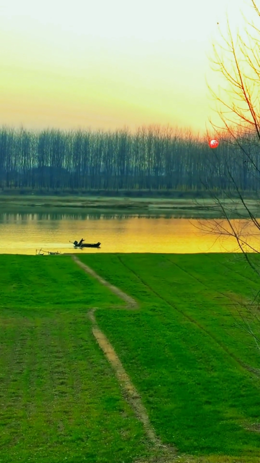 夕阳挂在树梢上了,红彤彤的,映得河面成了橘色,一