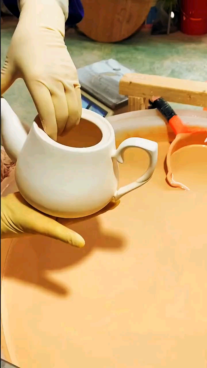 目睹陶瓷手艺人给茶壶上釉上釉非常的难过程中一旦釉水流进去整个壶就