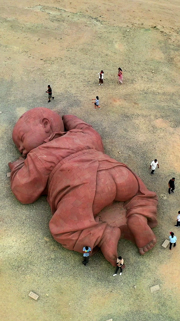 沙漠中的巨婴雕塑,像沉睡在大地母亲的怀抱!