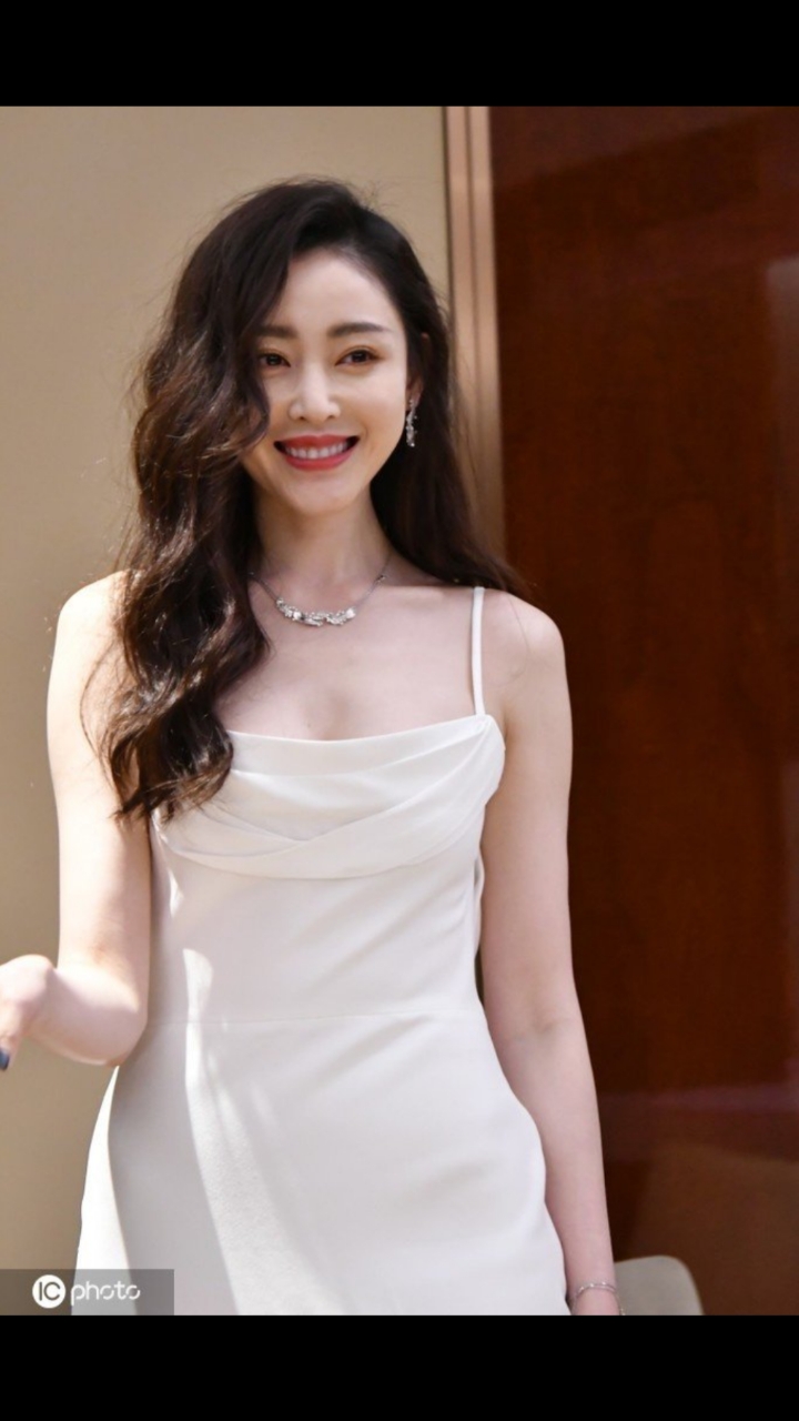 张天爱大波浪港风造型性感魅惑穿吊带裙坐姿优雅曲线迷人