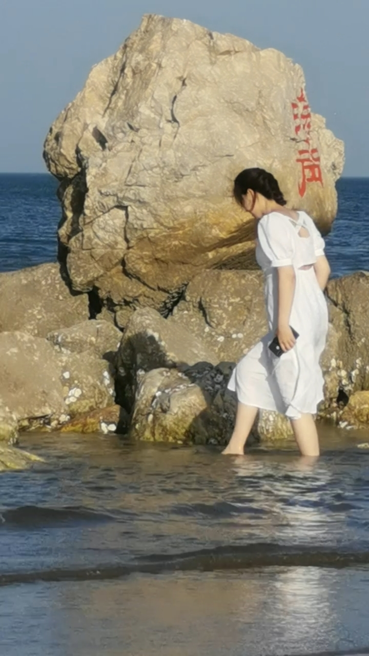 穿着白裙子,走在大海岸边,美女美