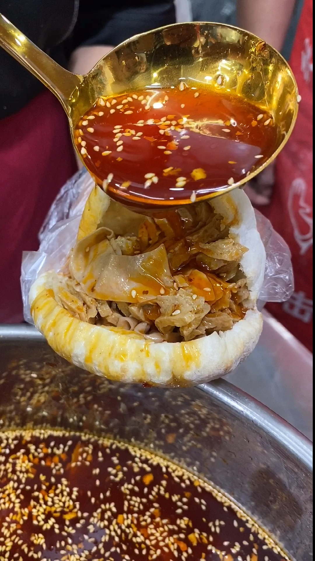 中间空心的烧饼,夹上裹满鸡汤的豆皮,再来一勺灵魂红油鸡汤,好吃不贵