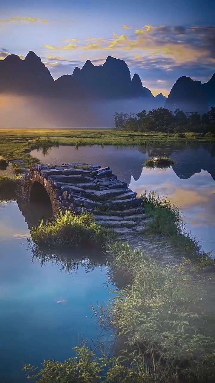 小桥横跨小河两岸,桥上的石板还略显湿润,上面结着墨绿的青苔.